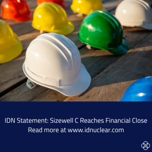 The image contains rows of hard hats on a wooden deck. Below the hard hats the text says - IDN Statement: Sizewell C reaches financial close. Read more at www.idnuclear.com