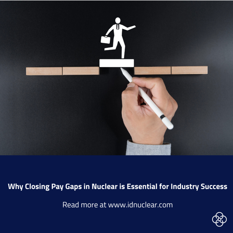 Illustration of a white stick-figure person carrying a briefcase, stepping across a gap between wooden blocks, with a hand drawing a bridge beneath them. Text below reads: “Why Closing Pay Gaps in Nuclear is Essential for Industry Success. Read more at idnuclear.com.