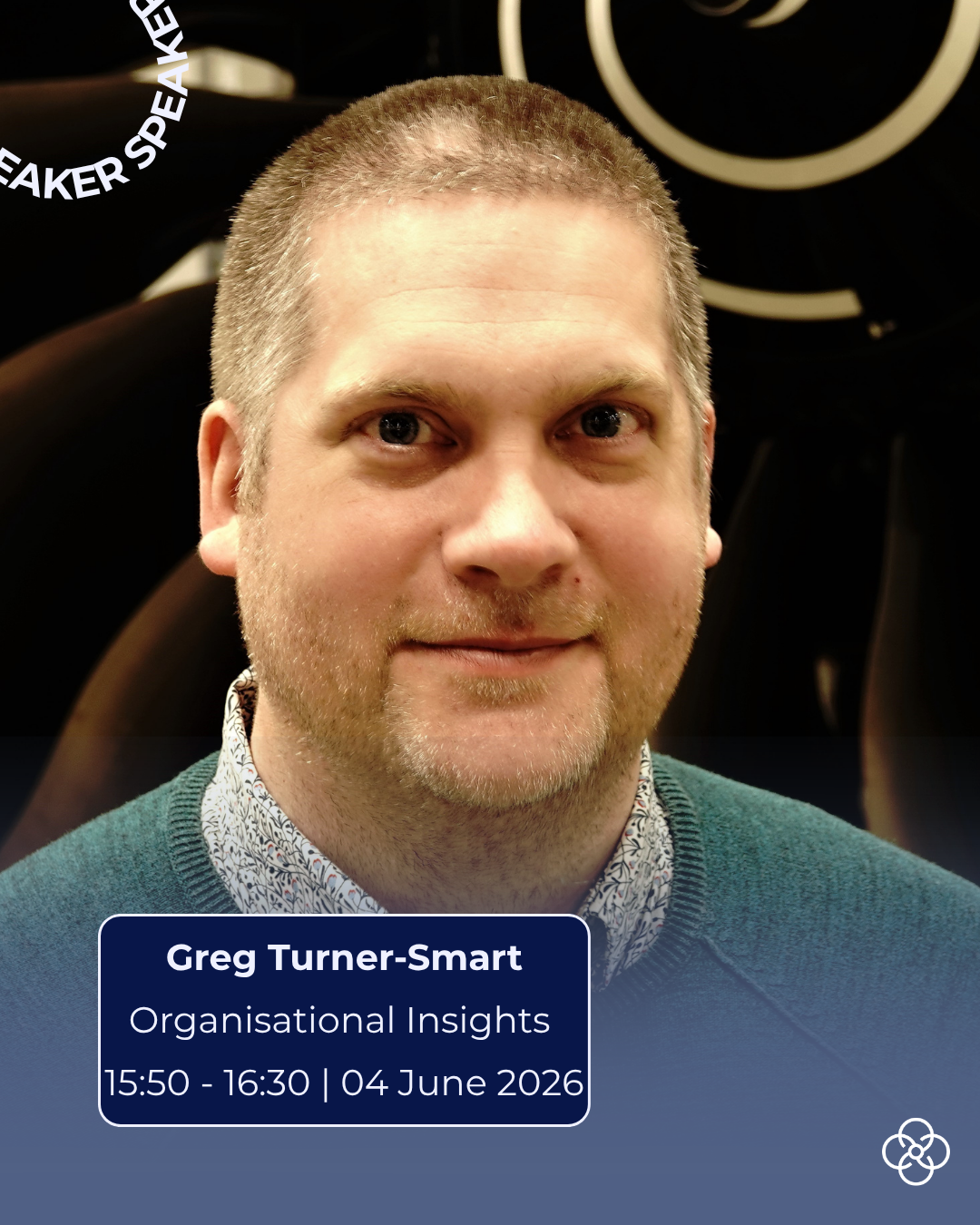 Promotional image showing Greg facing the camera, wearing a dark green jumper over a patterned shirt. The background features a dark backdrop with abstract circular light elements. Overlaid text reads: ‘SPEAKER’, ‘Greg Turner‑Smart’, ‘Organisational Insights’, and ‘15:50–16:30 | 04 June 2026’.